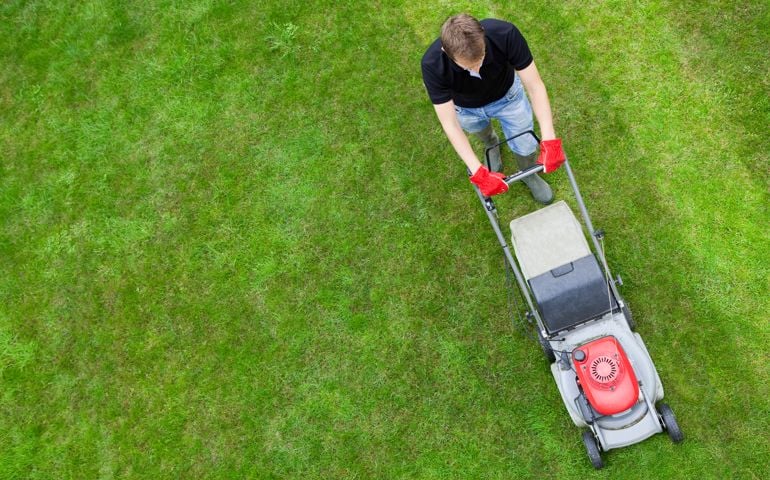 Man mowing a green lawn