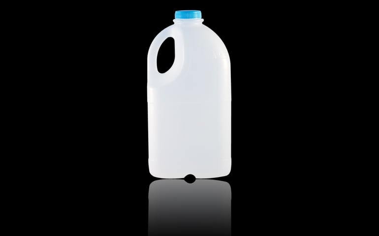 A gallon jug on a black background