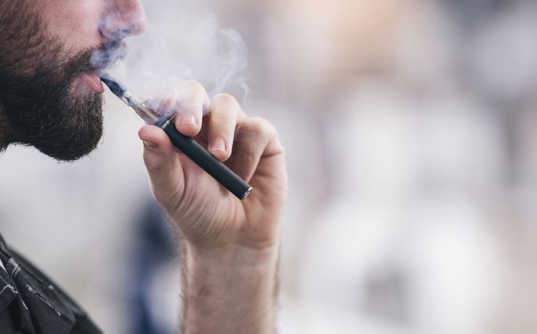 Smoking electronic cigarette. Shallow DOF. Developed from RAW; retouched with special care and attention; Small amount of grain added for best final impression. 16 bit Adobe RGB color profile.