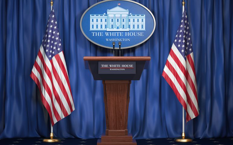Podium speaker tribune with USA flags and sign of White House.