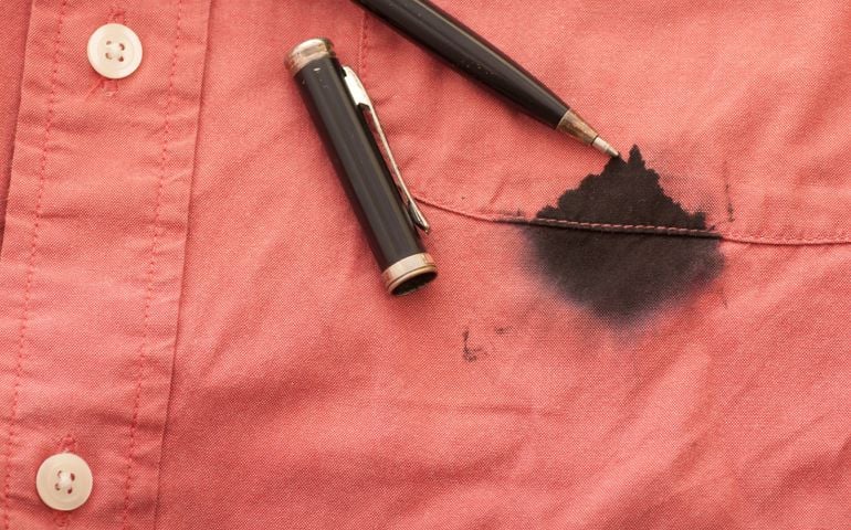 A Close Up of a Broken Pen Resting on the Men's Red Shirt Stained with Ink