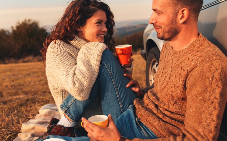 Beautiful young couple enjoying picnic time on the sunset.