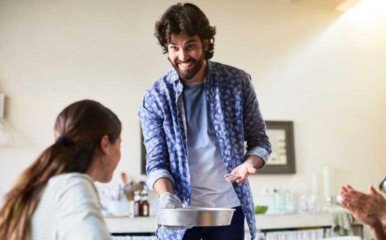 man proudly showing his partner the food he made