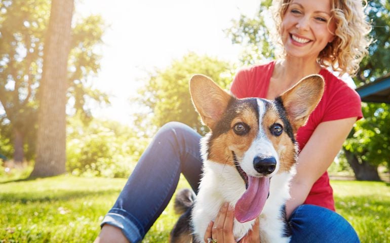 Shot of a young woman bonding with her dog in the park