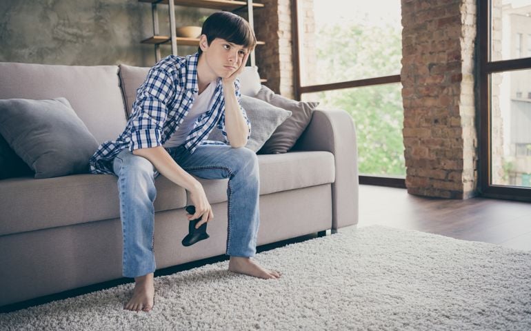 Boy with game controlled not interested in playing