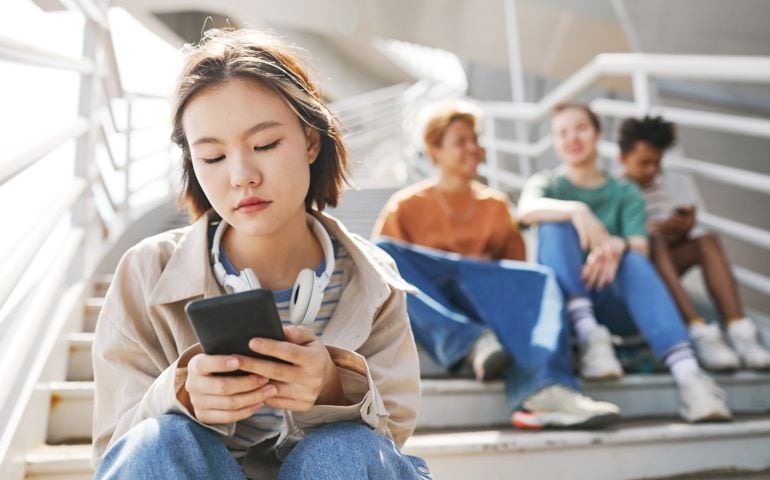 young girl using phone to text and cancel plans