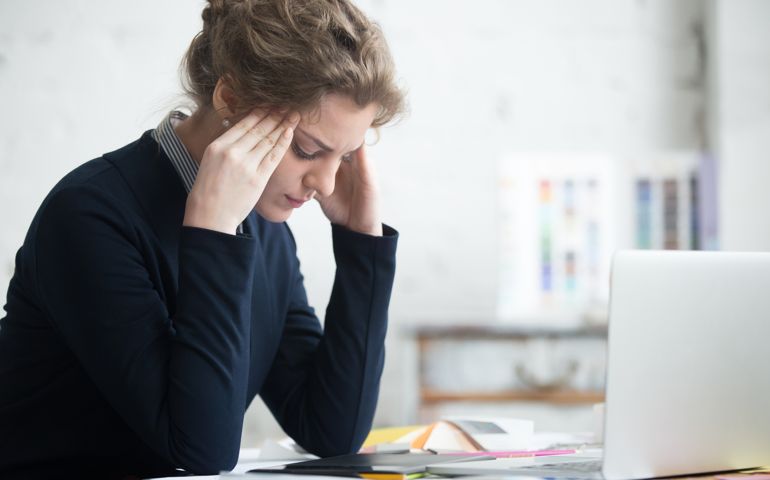 young woman looking stressed making decisions at work