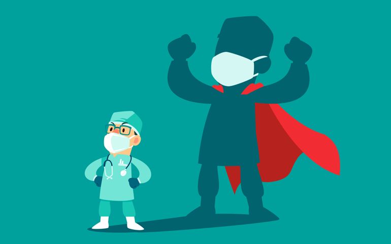 Brave doctor wearing medical mask and protection suit with his shadow as superhero. COVID-19 outbreak medical staff.