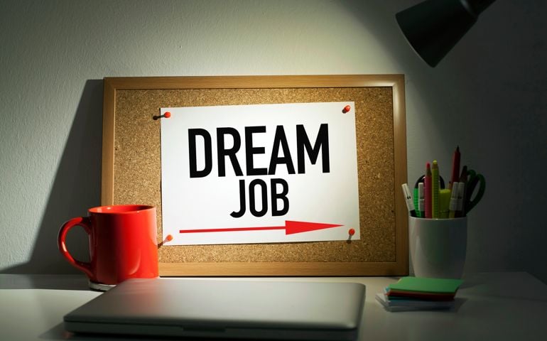 Dream job directional arrow sign note pinned on bulletin board in office interior