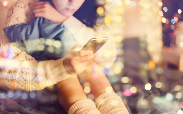 Girl texting on smartphone at home