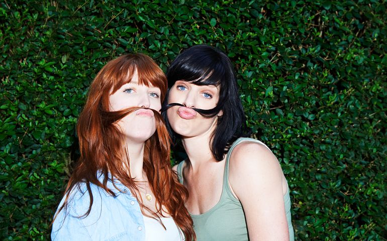 two women making moustaches with hair