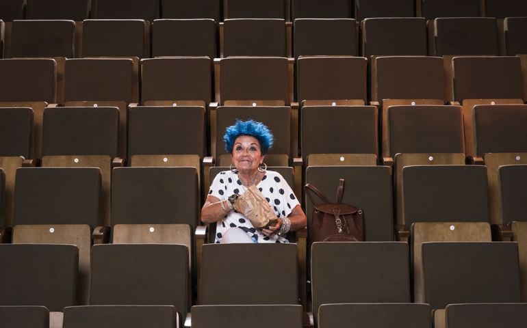 Senior woman with blue hair enjoying a movie.