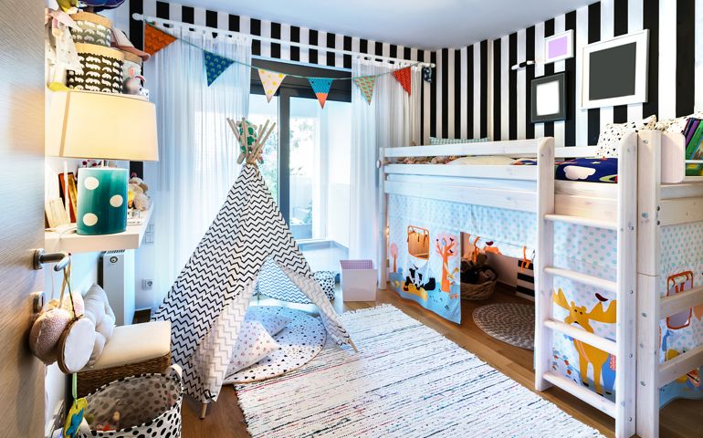 Kids bedroom with bunk wooden bed, teepee, stands, carpet frames and toys.