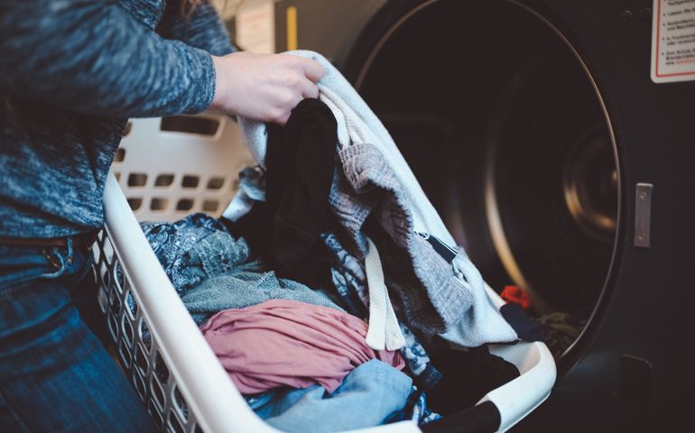 Close-up of a woman with a laundry basket washing clothes
