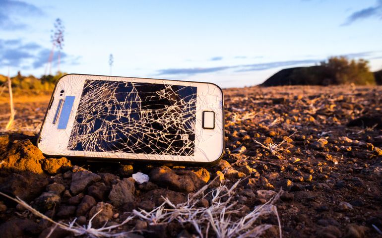 White Smartphone with Broken Display in the Desert