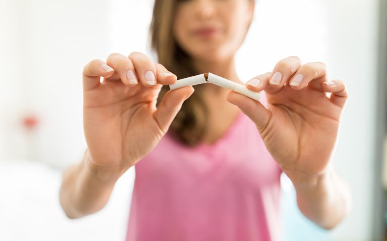 Closeup of woman's hands breaking cigarette to fight addiction