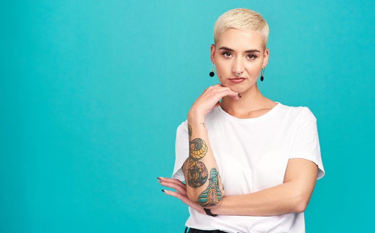 Studio shot of an attractive young woman posing against a turquoise background