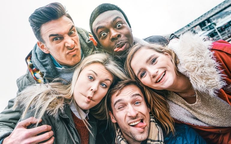Multiracial best friends taking selfie outdoor on autumn winter clothes - Happy youth concept with millennial people having fun together - Multicultural friendship against racism - Bright vivid filter