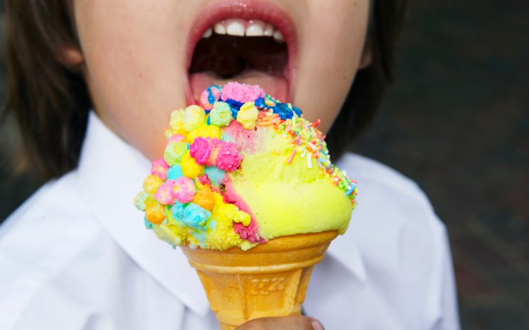 young boy eating colorful ice cream