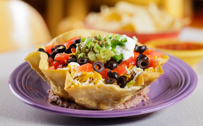 A hard-shelled taco salad on a table.