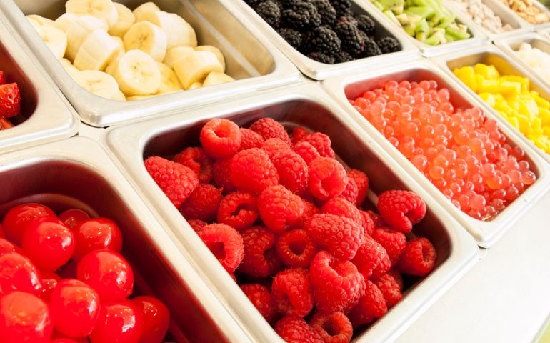 Frozen yogurt toppings bar. Yogurt toppings ranging from fresh fruits, nuts, fresh-cut candies, syrups and sprinkles.