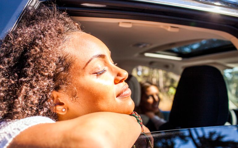 Black woman leaning out car window