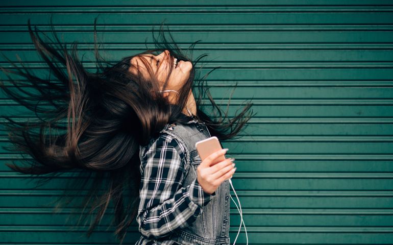 Young woman tossing hair while enjoying the music