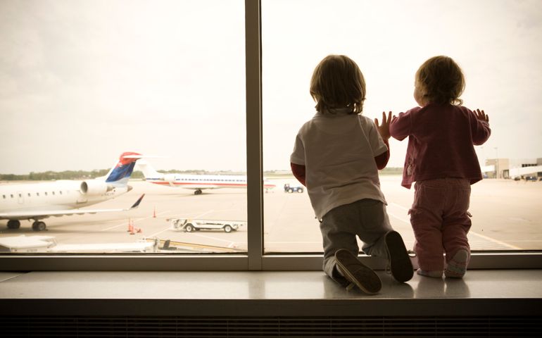 Two Children Excitedly Watch as Planes Land at the Airport