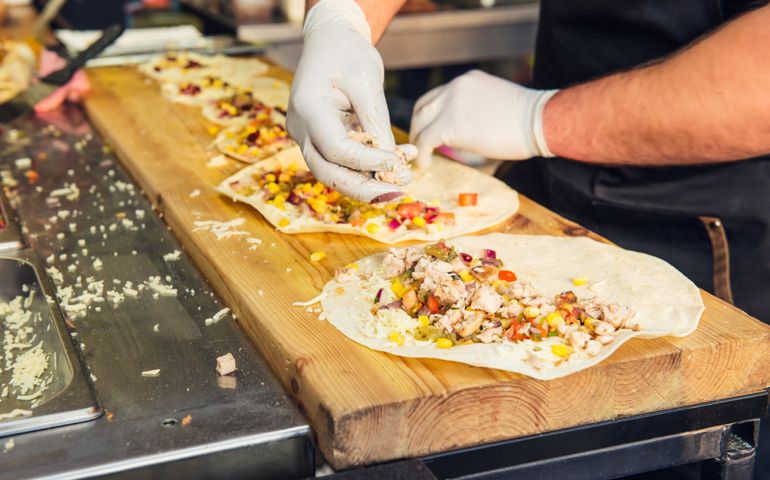 Chef's hands preparing mexican tacos