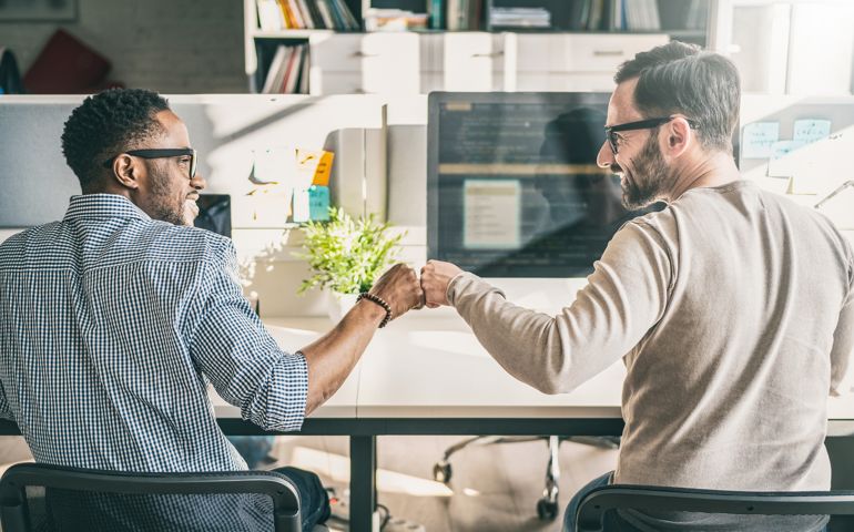 First bump between colleagues at work. Success in business. Everyday work in the office.