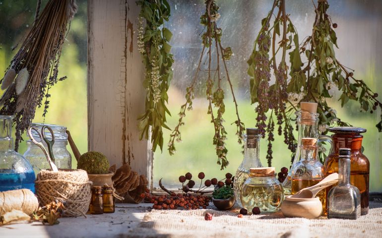 Magic potion bottles on the witch doctor table background close up.