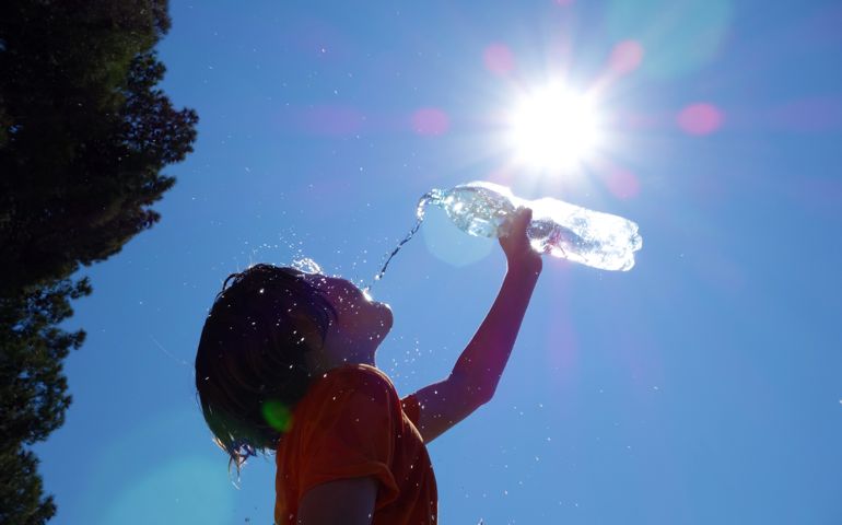 Child pouring water on himself.
