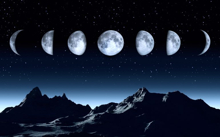 All phases of the moon on a clear dark sky with stars.