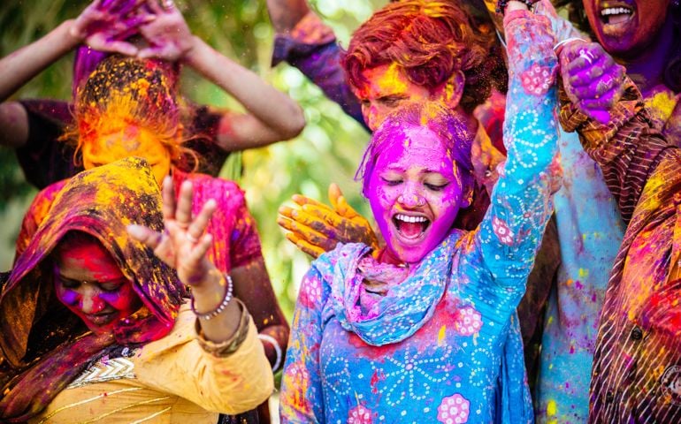 Indian Friends Dancing Covered on Holi colorful powder in India