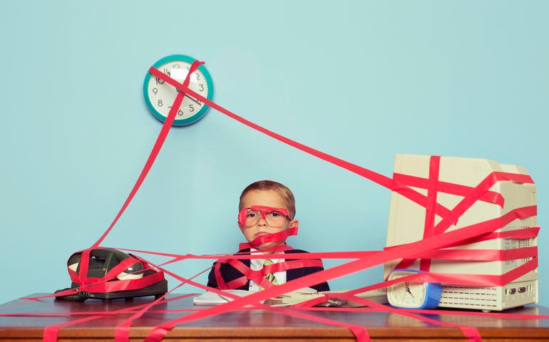 A young boy and businessman is all tied up in rules, regulations and unrealistic expectations. The boy is all taped up with red tape. His business is stuck in red tape and unable to perform. Retro styled.