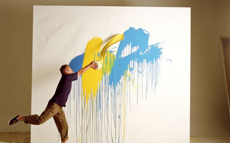 ARTIST THROWING PAINT AT CANVAS