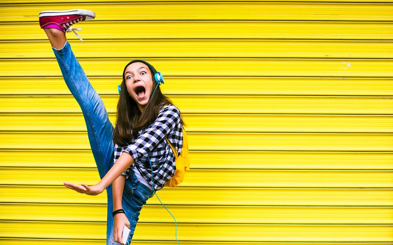 Beautiful teenage girl dancing to the music.