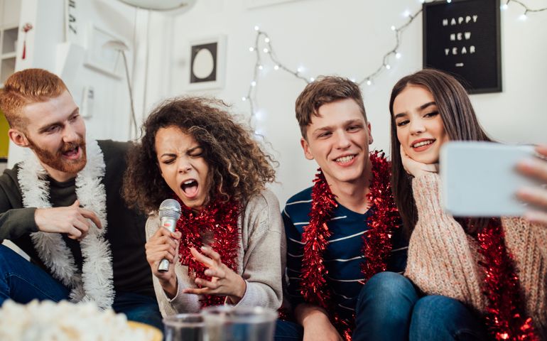 Funny young people singing karaoke and taking a selfie