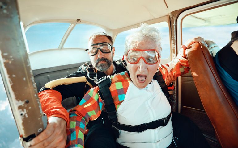 Close up of a senior woman and her instructor doing tandem skydiving