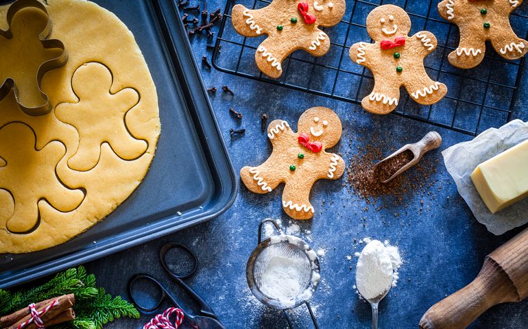 Top view of a bluish tint table with ingredients and utensils for preparing and baking Christmas cookies. Predominant colors are brown and blue. Low key DSRL studio photo taken with Canon EOS 5D Mk II and Canon EF 100mm f/2.8L Macro IS USM