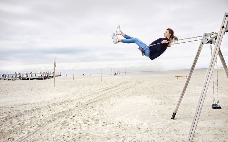 Girl on a swing on the beach