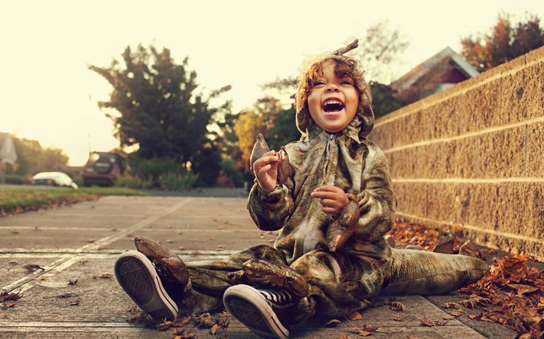 Toddler dressed in dinosaur costume on Halloween
