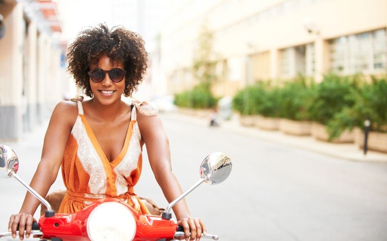 Black woman riding scooter