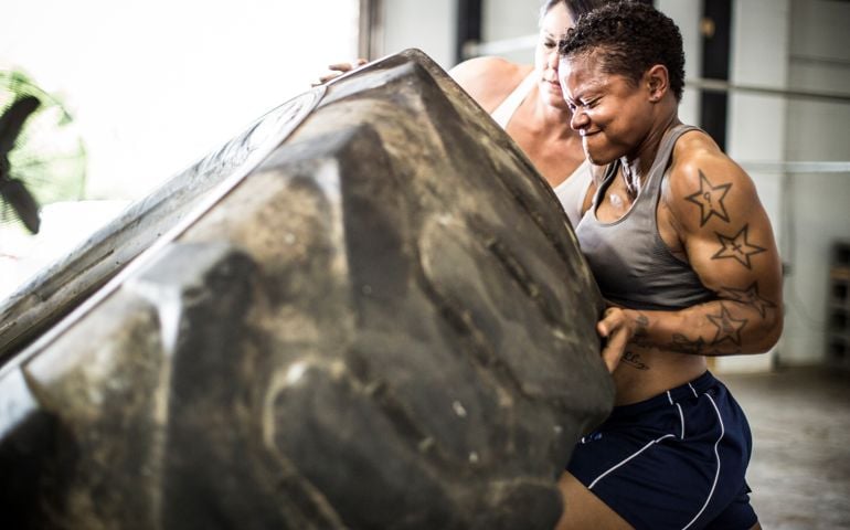 women doing tire-flip exercise