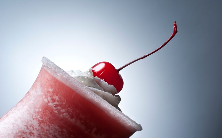 Detail image of strawberry daiquiri with cherry on top.