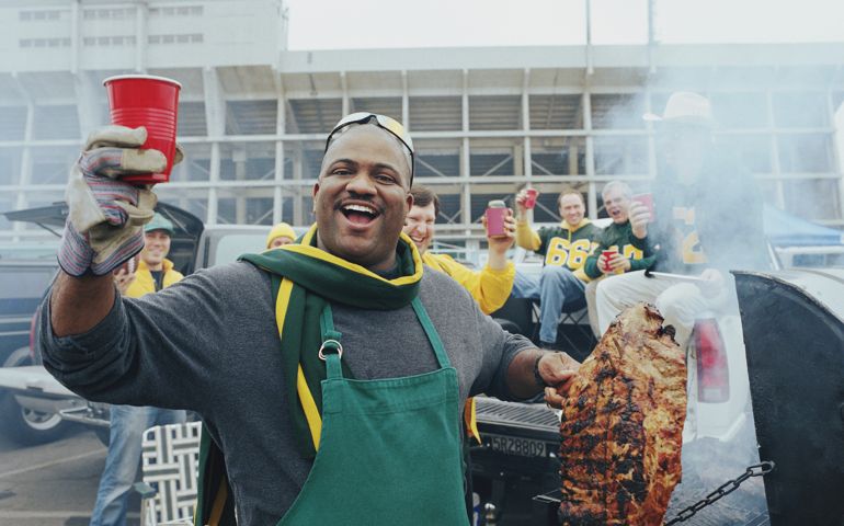Men having barbeque at tailgate party in stadium parking lot