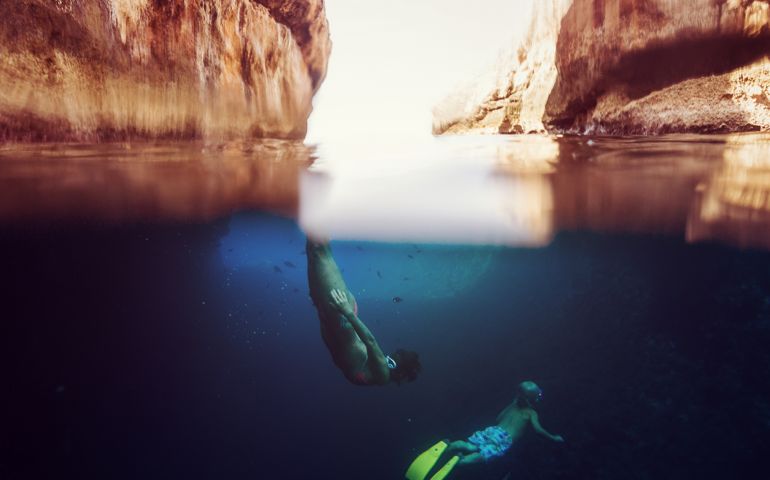 Mother snorkeling with son, underwater view