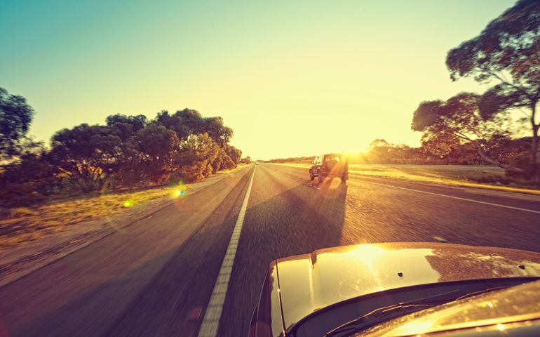 cars driving towards the sun on highway in Australia