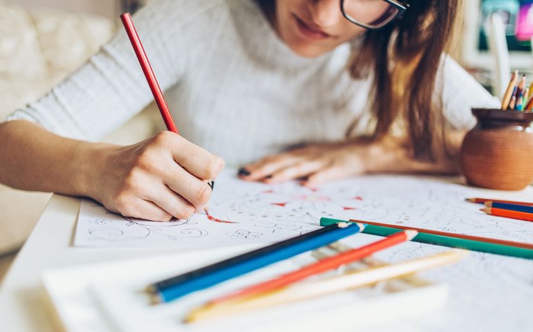 Woman coloring doodle with color pencils for relaxation.