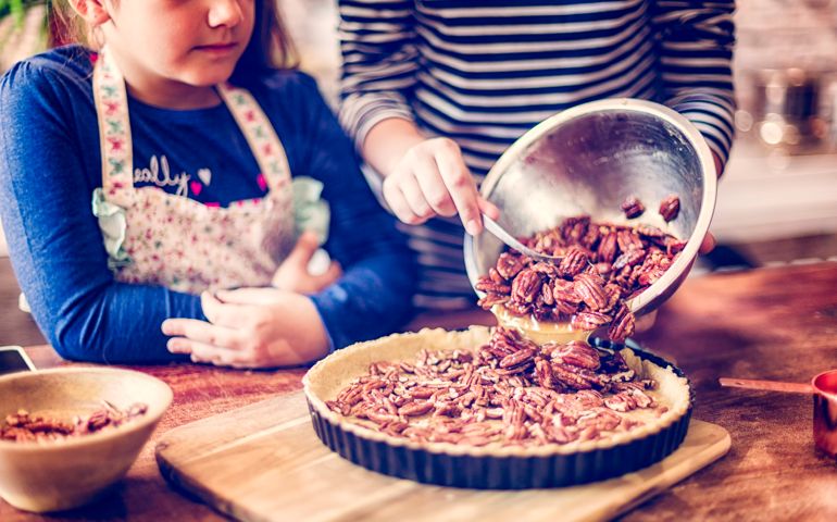 Two Girls preparing homemade pecan pie for the holidays.